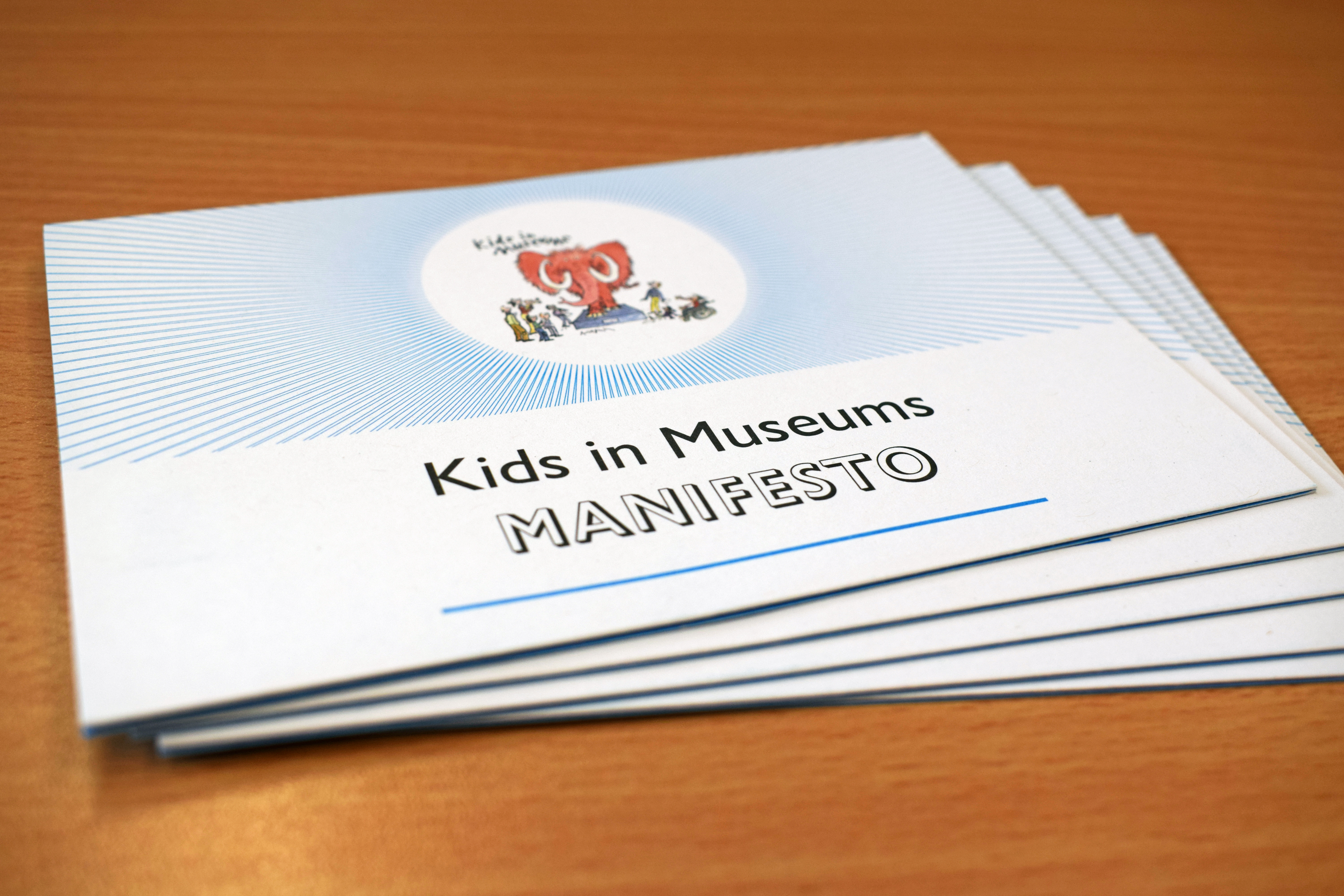 A pile of paper copies of the Kids in Museums Manifesto lying on a table.