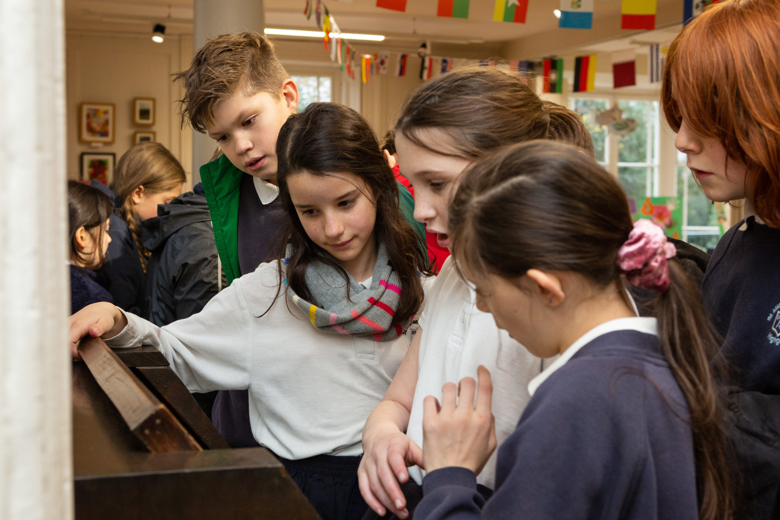 A group of primary school children look at an interactive screen in a gallery at Lauderdale House.