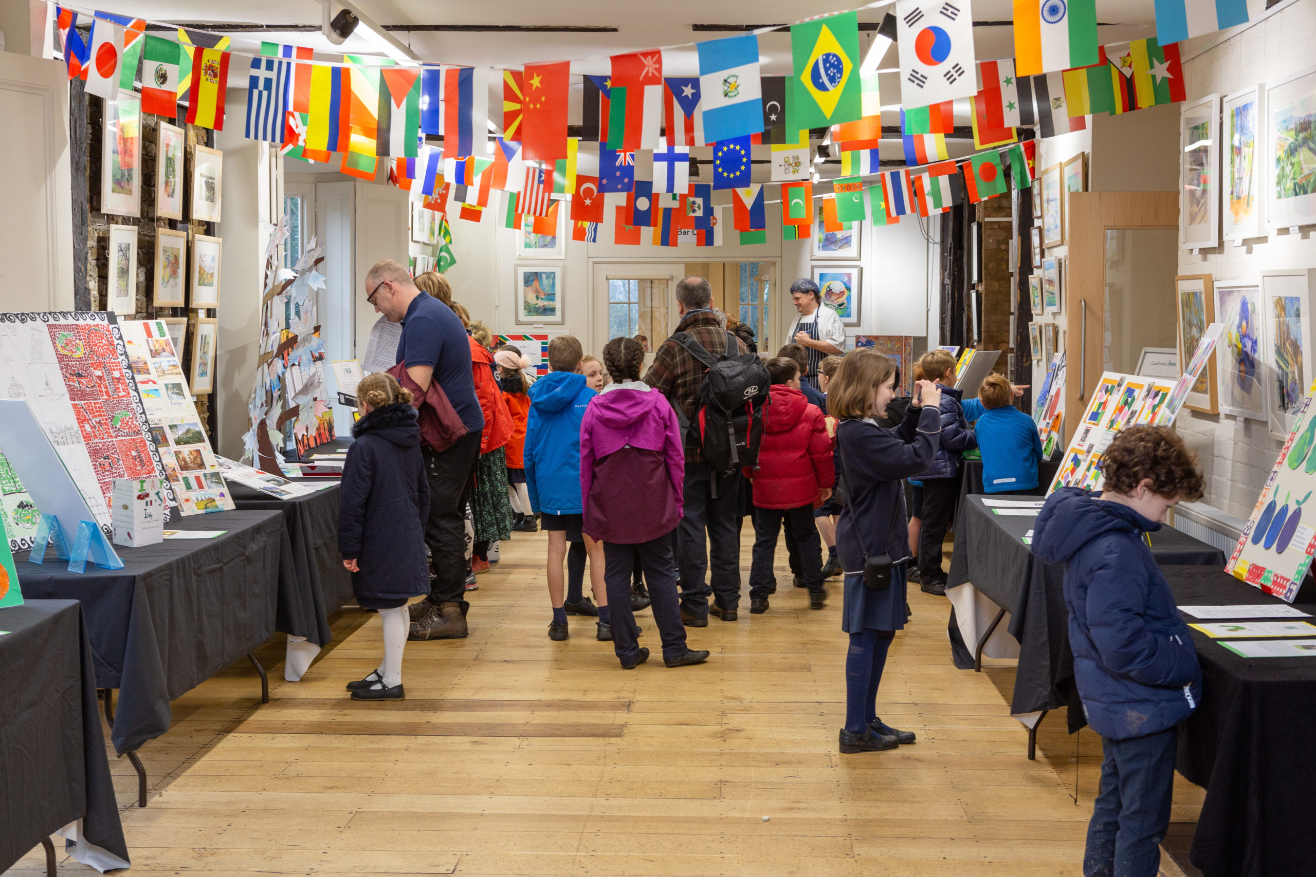 Children and teachers fill at a gallery at Lauderdale House decorated with flags from around the world.