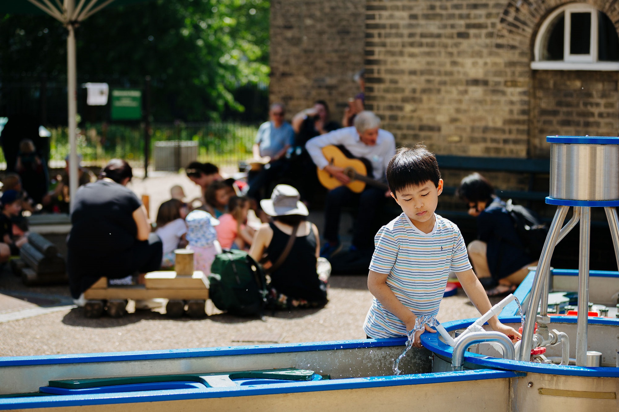 A child plays with water in the museum's outdoor Splash Zone.