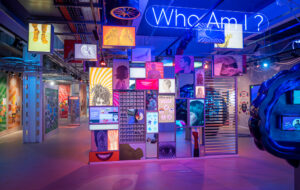 The inside of Eureka Science and Discovery; a room filled with colourful digital screens and interactives,