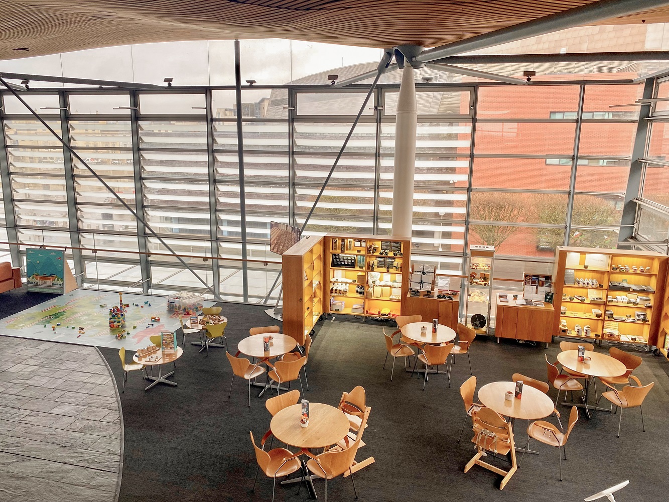 An image of the Senedd Café from above. On the left hand side is a children's playmat and play area with toys.